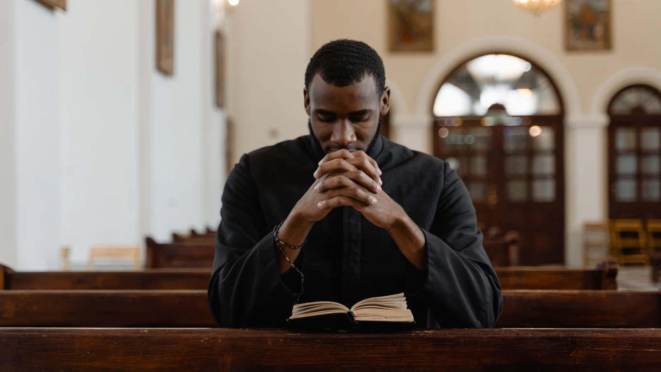 young man kneeling and praying in the church